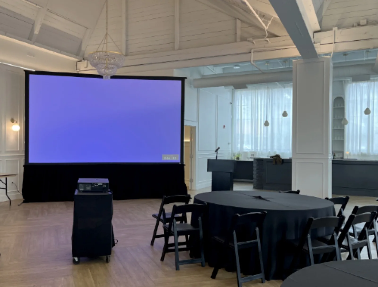 The Highline — large-format projection screen and round table setup
